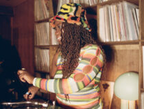 Gayance DJing among shelves of vinyl records